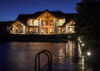 Evening view of a luxury timber frame home on Okanagan Lake